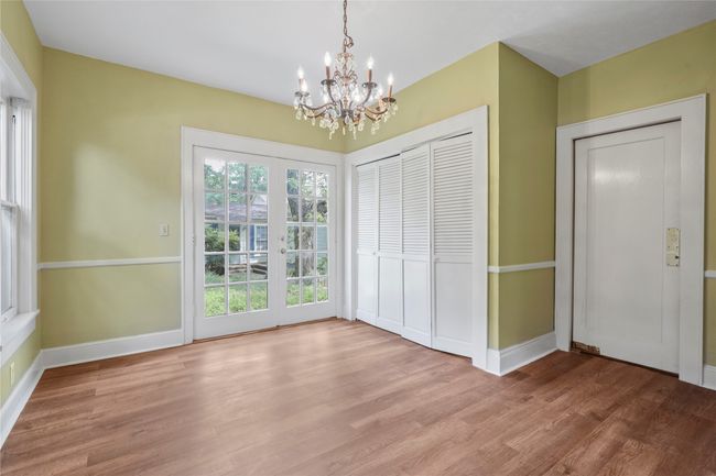 Unfurnished dining area featuring a chandelier, wood finished floors, and baseboards | Image 8