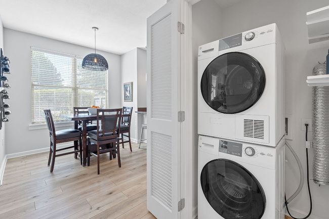 Laundry room featuring stacked washer / dryer and light wood-style floors | Image 20