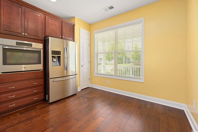 Kitchen featuring appliances with stainless steel finishes, dark wood-type flooring, visible vents, and baseboards | Image 5