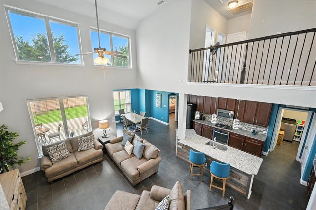 Living room with high vaulted ceiling, plenty of natural light, and ceiling fan | Image 9