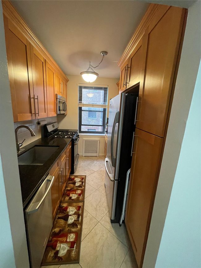 Kitchen with a sink, stove, dishwasher, fridge, and decorative backsplash | Image 7