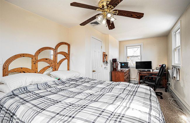 Carpeted bedroom with ceiling fan and a baseboard radiator | Image 10
