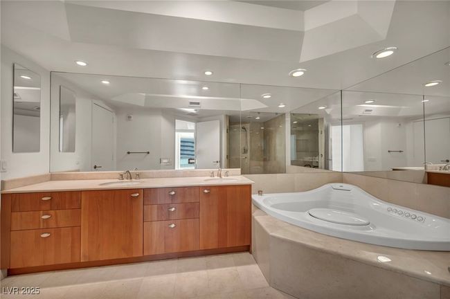 Bathroom with a jetted garden tub, a sink, double vanity, and a stall shower | Image 42