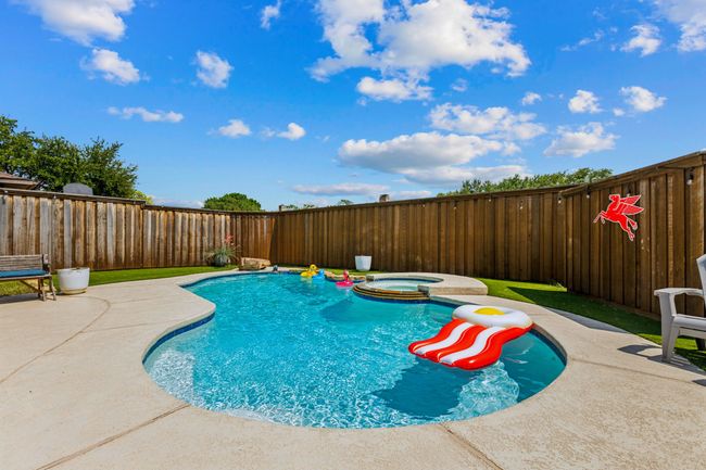 View of swimming pool with a fenced backyard, a pool with connected hot tub, and a patio | Image 25