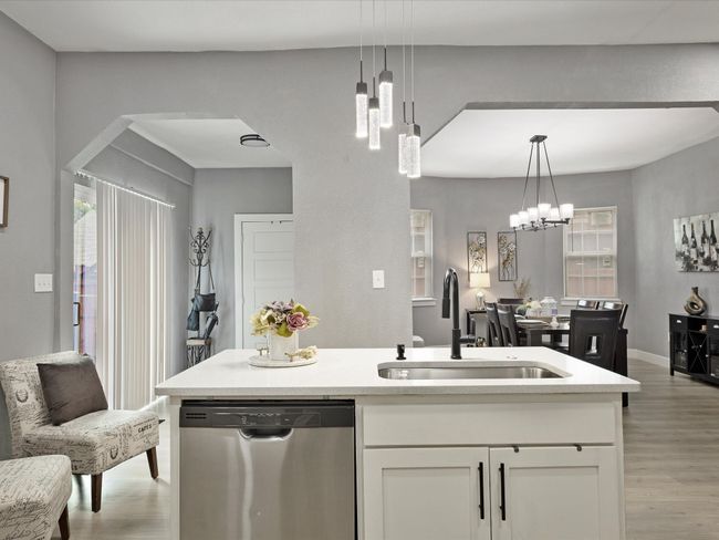 Kitchen with dishwasher, a sink, a chandelier, and light wood finished floors | Image 20