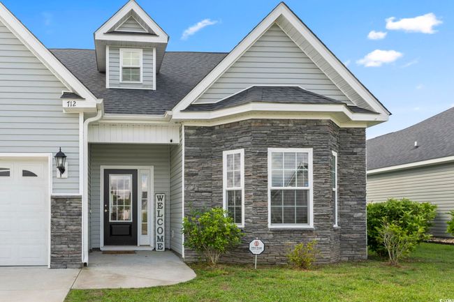 Property entrance featuring a lawn, a shingled roof, and stone siding | Image 36