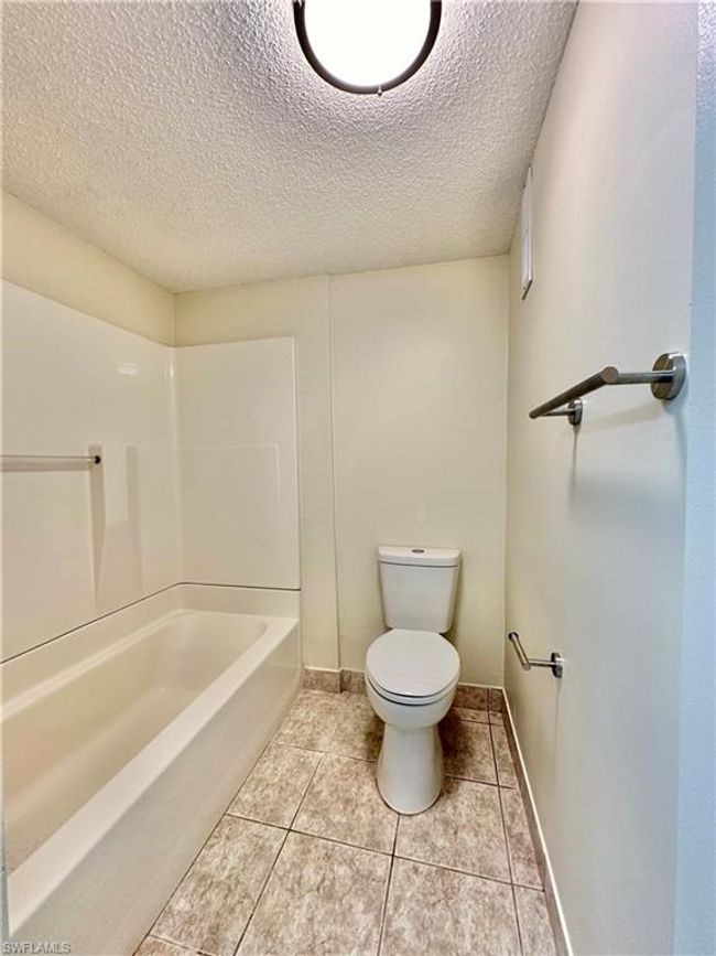 Bathroom with a textured ceiling and tile patterned floors | Image 9