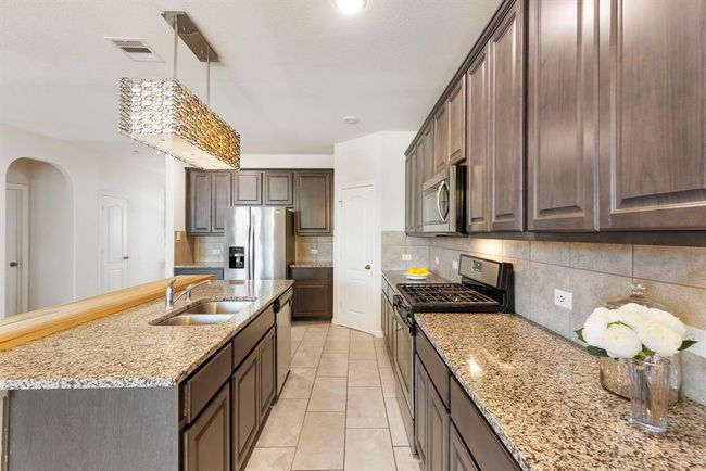 This kitchen has plenty of cabinet & countertop space. | Image 14