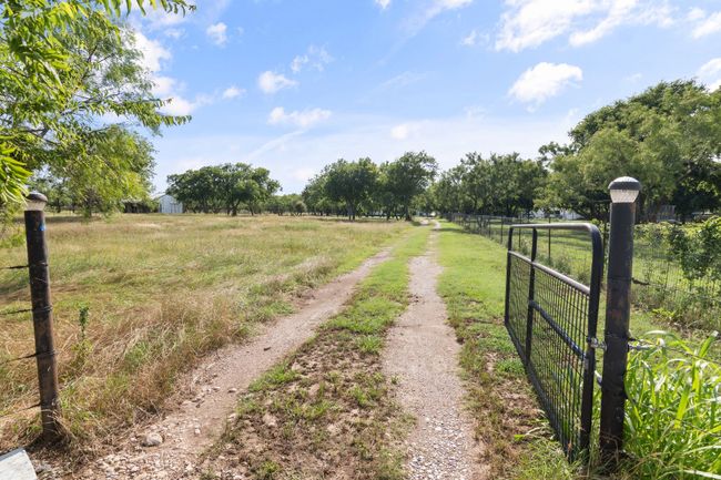 View of dirt / gravel driveway featuring a view of countryside and a gated entry | Image 35