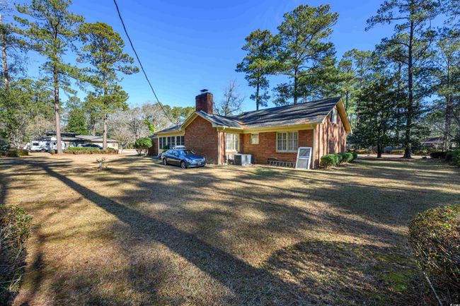 View of property exterior featuring central AC unit and a yard | Image 9