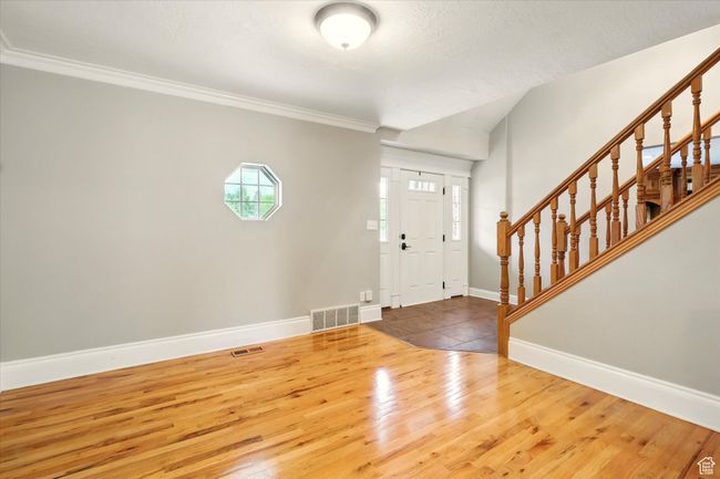Entrance foyer featuring stairway, wood finished floors, and ornamental molding | Image 34