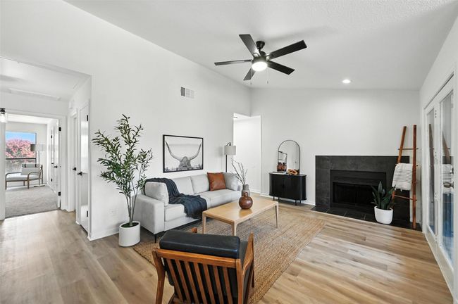 Living area with light wood finished floors, a ceiling fan, a tile fireplace, and recessed lighting | Image 7