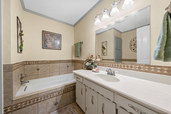 Bathroom with vanity, a garden tub, ornamental molding, and tile patterned floors | Image 22