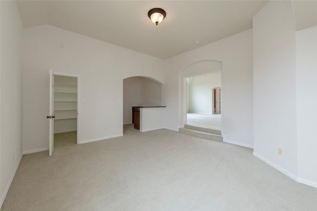 Unfurnished room with light colored carpet, arched walkways, and lofted ceiling | Image 34