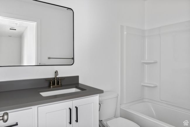 Bathroom featuring toilet, shower combination, and vanity | Image 21