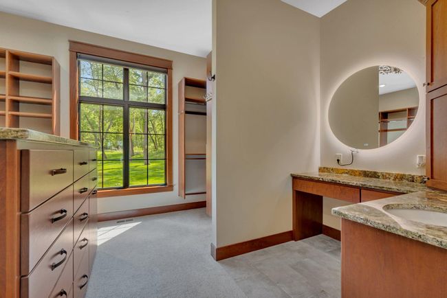 Thoughtfully designed with built-ins, a vanity and island offers seamless storage and functionality. | Image 55