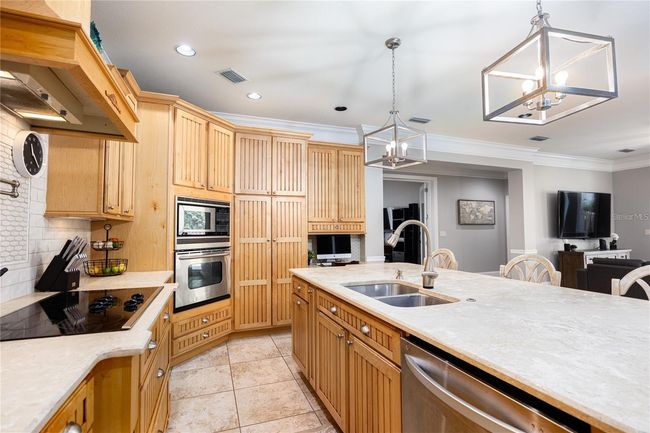 Fully upgraded kitchen with stainless steel appliances, custom cabinets, granite counters, large island with seating, and much more! | Image 10