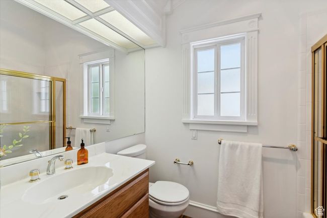 Guest full bath with plenty of natural light, toilet, tiled shower, and vanity | Image 20