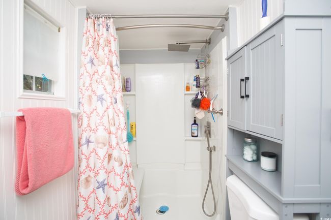 Bathroom with a shower with shower curtain and toilet | Image 24