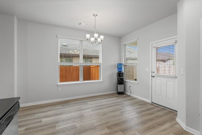 Unfurnished dining area featuring light wood-type flooring, a chandelier, and baseboards | Image 12