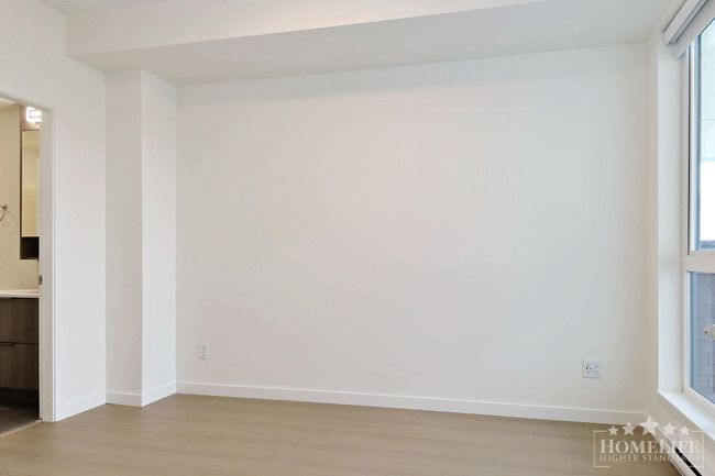 Spare room featuring a baseboard heating unit, baseboards, and wood finished floors | Image 10