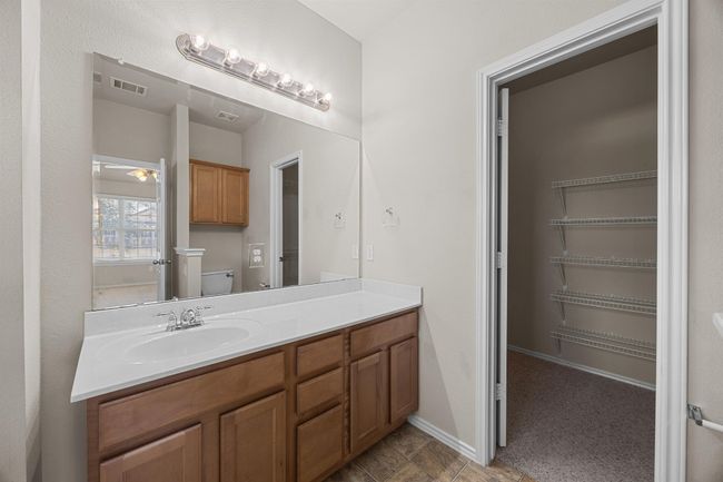 Bathroom with toilet, vanity, visible vents, and baseboards | Image 19