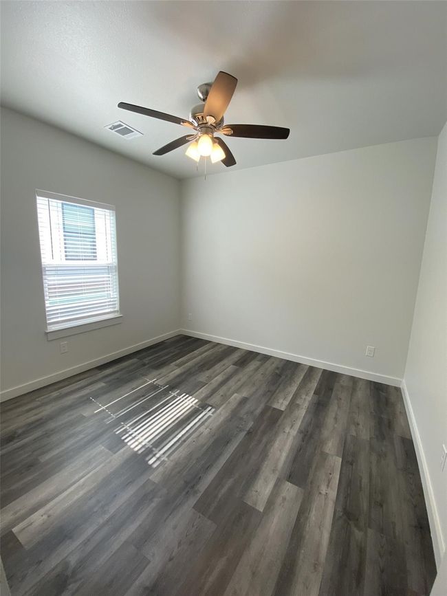 Empty room featuring baseboards, dark wood-style floors, and a ceiling fan | Image 7