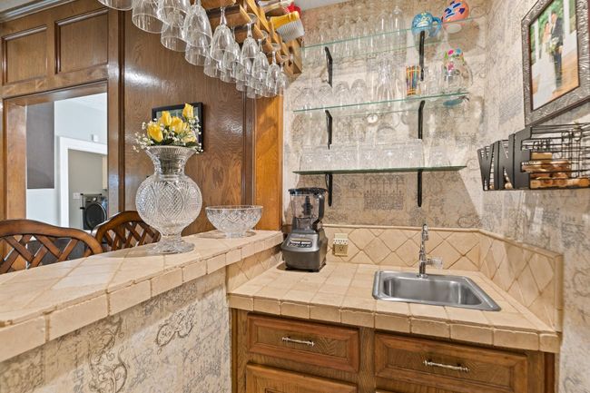 Stylish wet bar located in the family room, perfect for entertaining and hosting gatherings. This convenient feature makes it easy to serve guests while enjoying the comfortable, casual atmosphere of the main living space. | Image 13