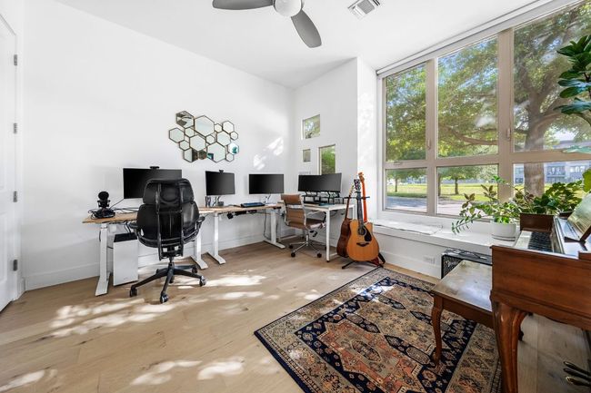 Office space with wood finished floors, visible vents, a ceiling fan, and baseboards | Image 6