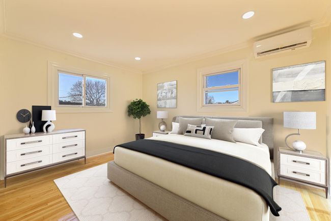 Bedroom with a wall mounted air conditioner, ornamental molding, and light wood-type flooring | Image 34