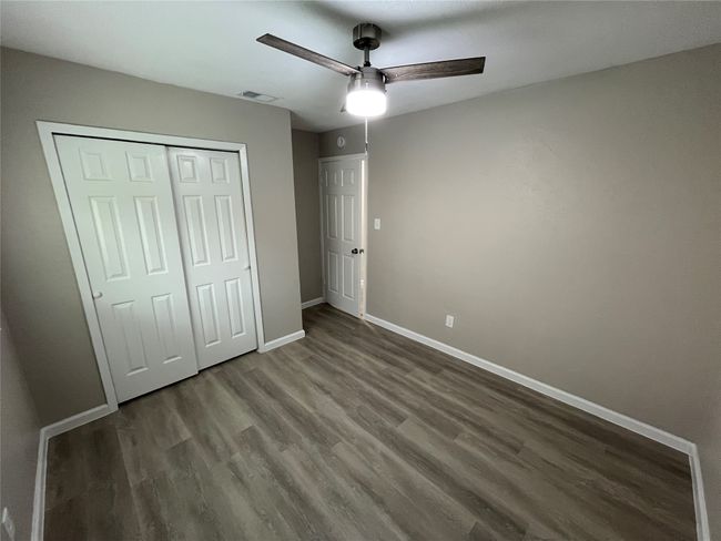 Unfurnished bedroom featuring baseboards, wood finished floors, a closet, and ceiling fan | Image 15