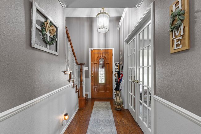 Entryway with a notable chandelier and dark wood-type flooring | Image 14