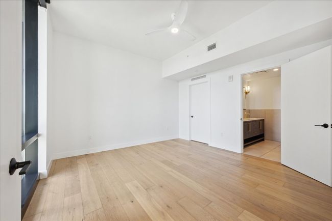 Unfurnished bedroom featuring light wood finished floors, connected bathroom, and ceiling fan | Image 11