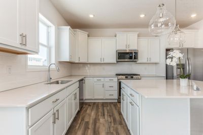 (Photo of an inventory home, actual features will vary) This kitchen features a walk-in pantry, white cabinets, quartz kitchen countertops, under mount sink, LED lighting, LVP flooring, stainless appliances and more! | Image 2