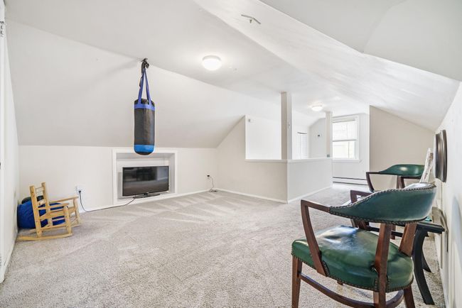 Living area featuring baseboard heating, baseboards, vaulted ceiling, and carpet | Image 21