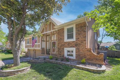 View of front facade featuring a garage, central AC unit, and a front lawn as well as the gate to the back yard. | Image 3