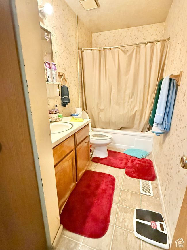 Bathroom featuring tile patterned floors, shower / tub combo, and vanity | Image 8