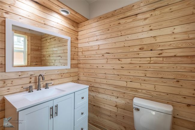 Bathroom featuring toilet, wood walls, and vanity | Image 10