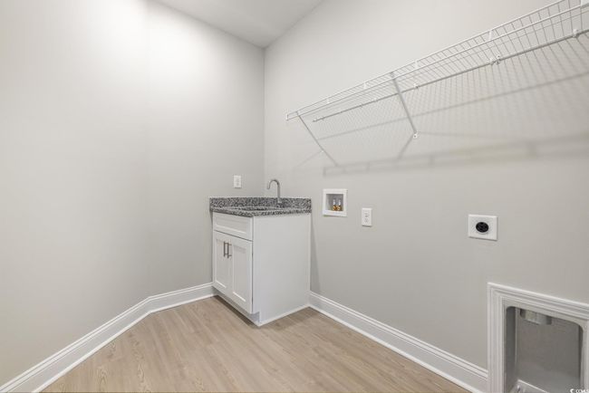 Clothes washing area with cabinets, sink, hookup for a washing machine, hookup for an electric dryer, and light hardwood / wood-style floors | Image 26