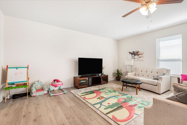 Living room featuring a ceiling fan, baseboards, and wood finished floors | Image 6