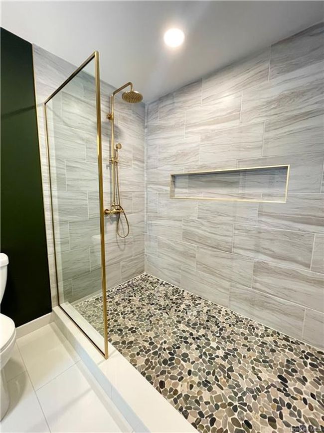 Example of the work we do. Not this house. Bathroom with tiled shower, tile patterned flooring, and toilet | Image 15