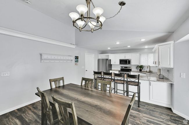 Dining space featuring lofted ceiling, recessed lighting, baseboards, a chandelier, and dark wood finished floors | Image 11