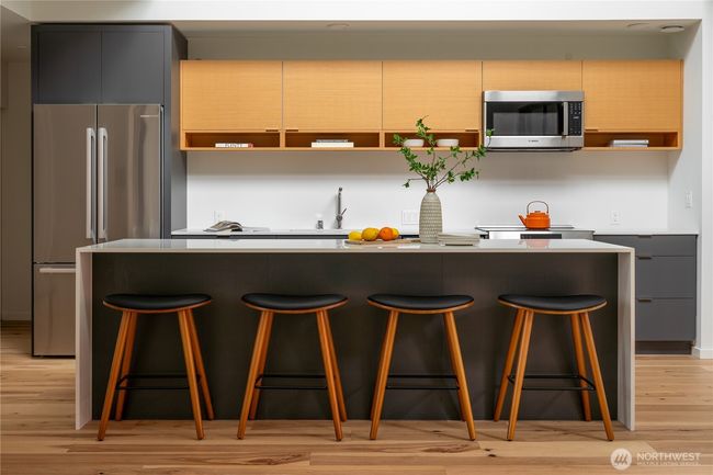 The kitchen is a chef's dream, featuring elegant quartz countertops, high-end Bosch appliances, an induction stove, and Abodian cabinetry, which offers ample storage space for all your culinary needs. | Image 9
