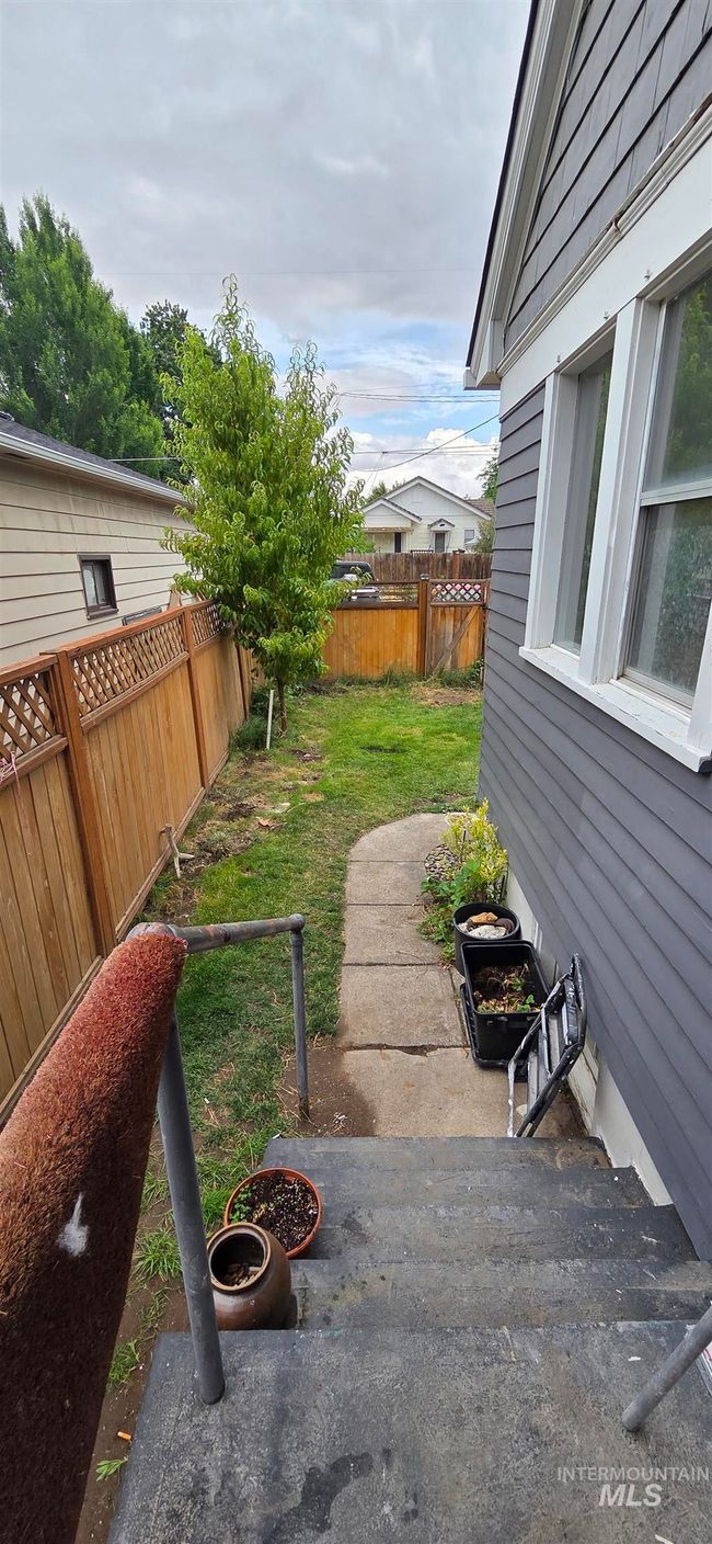 Fenced backyard with a patio area | Image 24