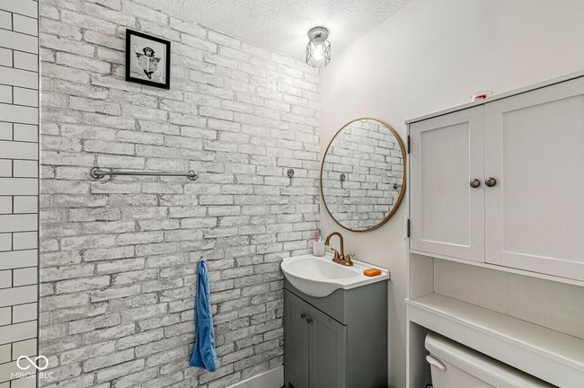 bathroom with vanity, a textured ceiling, and toilet | Image 12