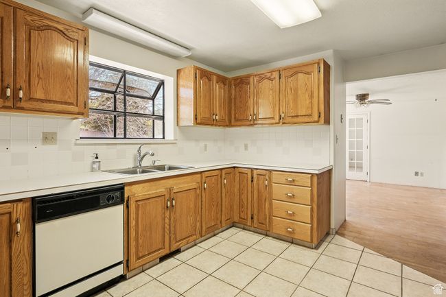 Kitchen with white dishwasher, tasteful backsplash, and brown cabinetry | Image 15