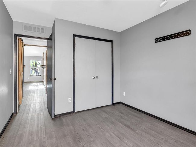Unfurnished bedroom featuring wood finished floors, visible vents, a closet, and baseboards | Image 15