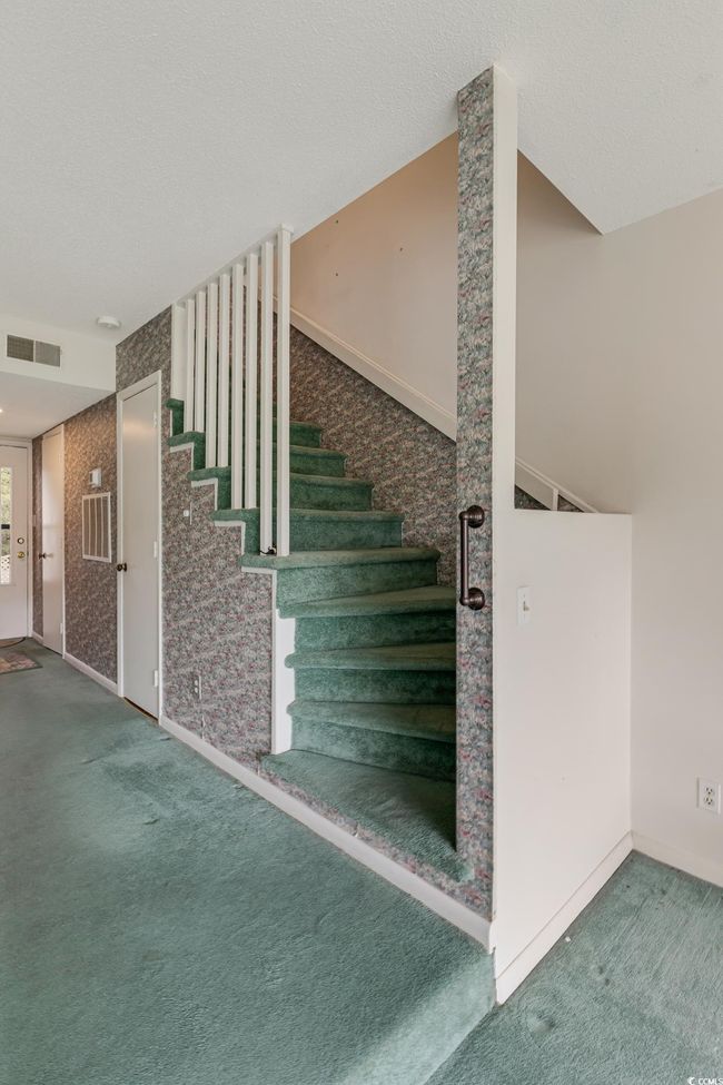 Stairway featuring carpet flooring, a textured ceiling, baseboards, and visible vents | Image 17
