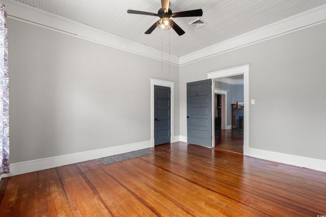 Empty room featuring hardwood / wood-style floors, crown molding, and ceiling fan | Image 22