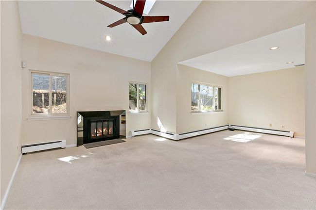 Living room with cathedral ceiling, skylights, fireplace, open to the den. | Image 4